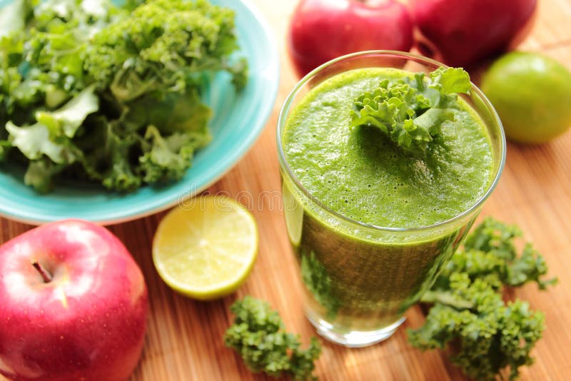 Glass with green smoothie with kale leafs