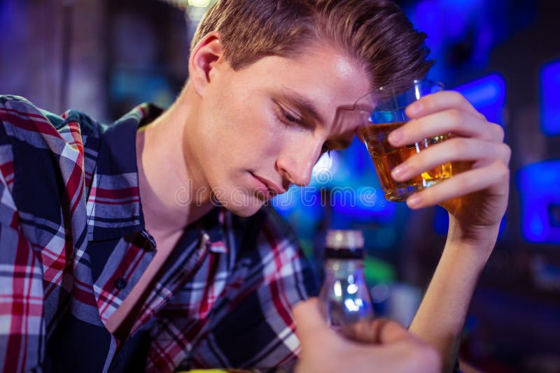 Glass hållande whisky för ledsen man arkivfoton Glass hållande whisky för ledsen man arkivfoton