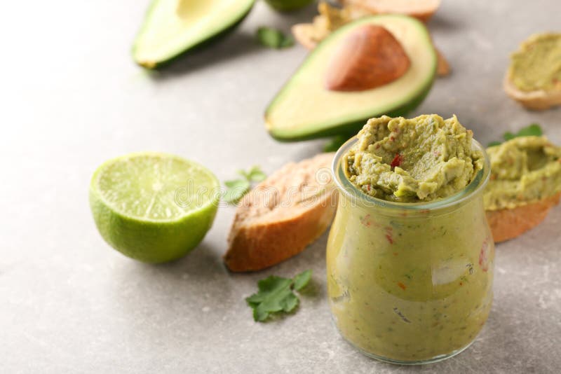 Glass jar with delicious guacamole on table stock image