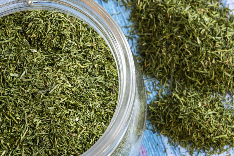 Glass Jar Filled with Green Dehydrated Dill with Spices Inside Stock