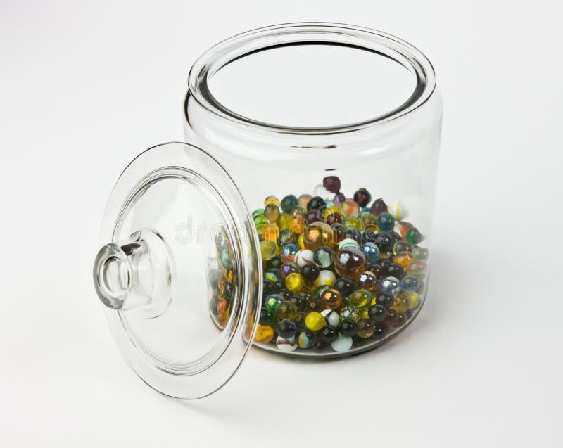 Glass jar half full of colorful glass marbles