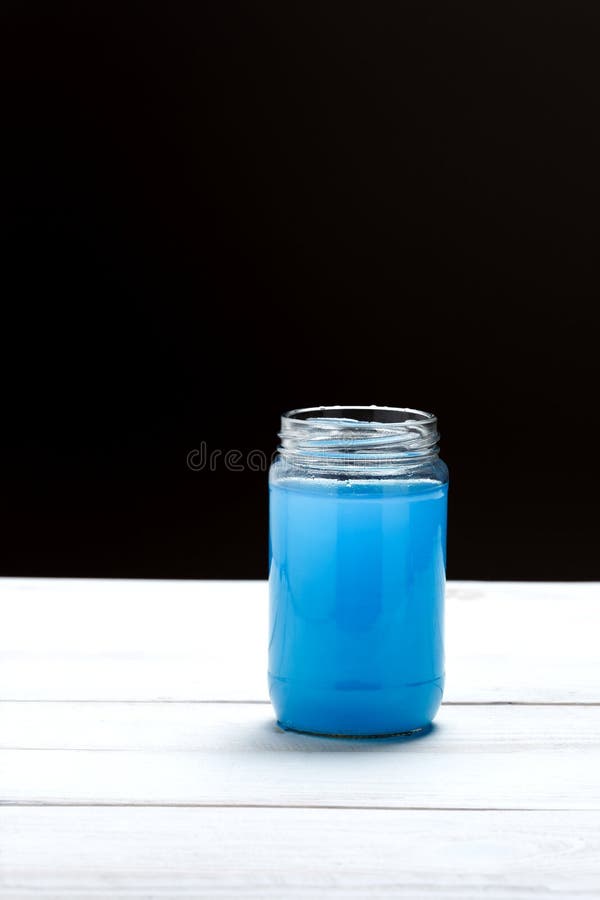 Glass Jar with a Liquid of Blue Color on Black and White Background