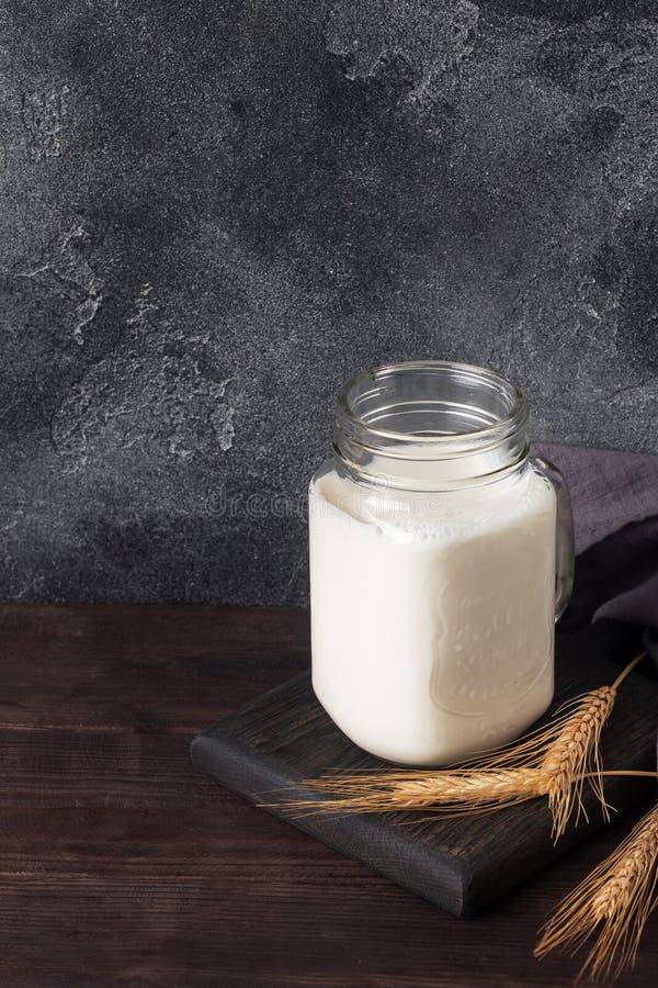 Glass Jar with Milk on a Dark Background. Copy Space Stock Photo