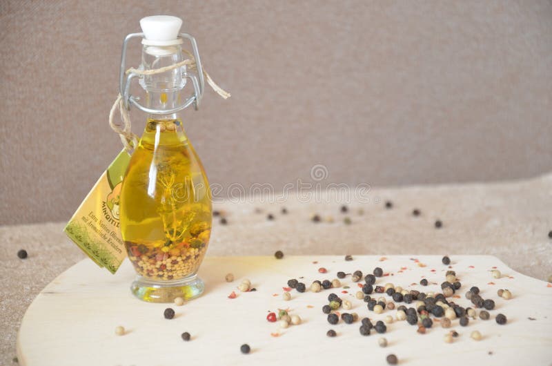 A glass jar with olive oil and spices and sprinkled with pepper on a table royalty free stock photos A glass jar with olive oil and spices and sprinkled with pepper on a table royalty free stock photos