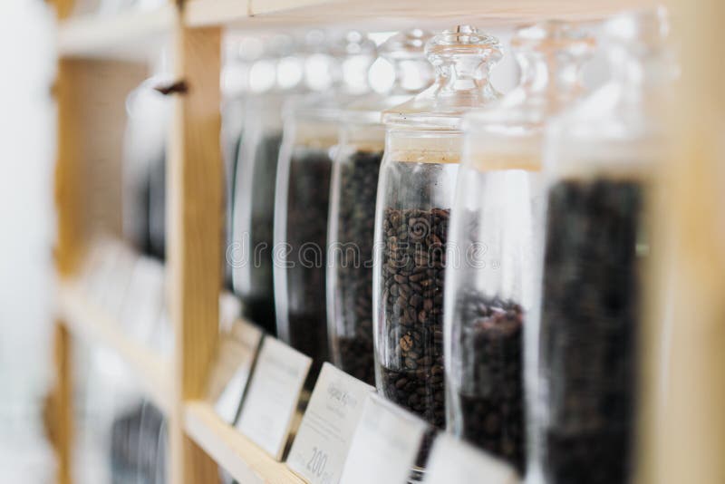 Glass Jars of Coffee Beans Stand on the Shelf of the Store. Stock Photo