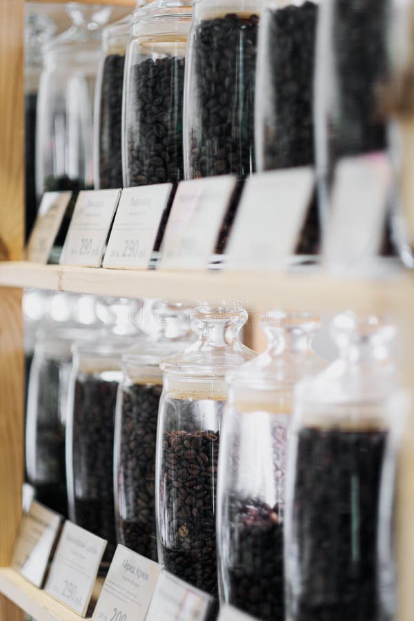 Glass Jars of Coffee Beans Stand on the Shelf of the Store. Stock Photo