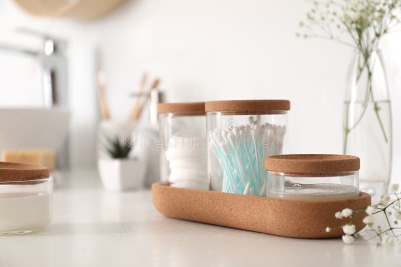 Glass Jars with Cotton Pads and Buds on Countertop in Bathroom. Space for Text Stock Image