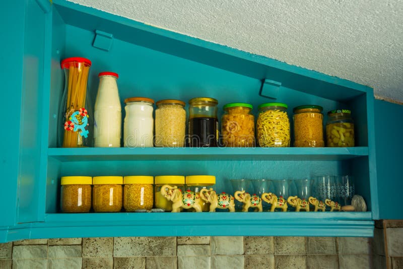 Glass Jars with Products on a Wooden Shelf in the Kitchen. Stock