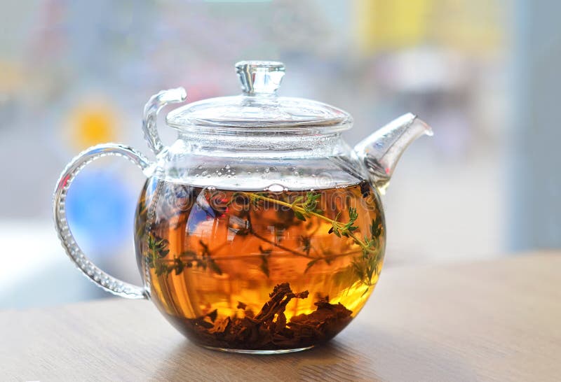 GLASS KETTLE with a TEA is on the TABLE on a LIGHT Background Stock