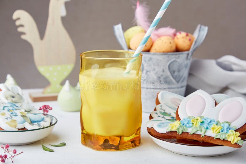 Glass with Milk and Decorated Easter Cookies among Table Decorations