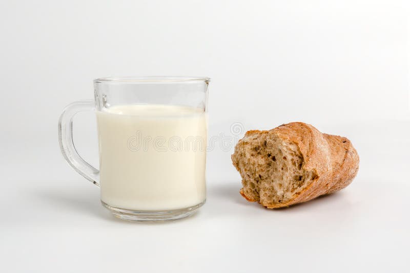 Glass mug with milk and a slice of bread