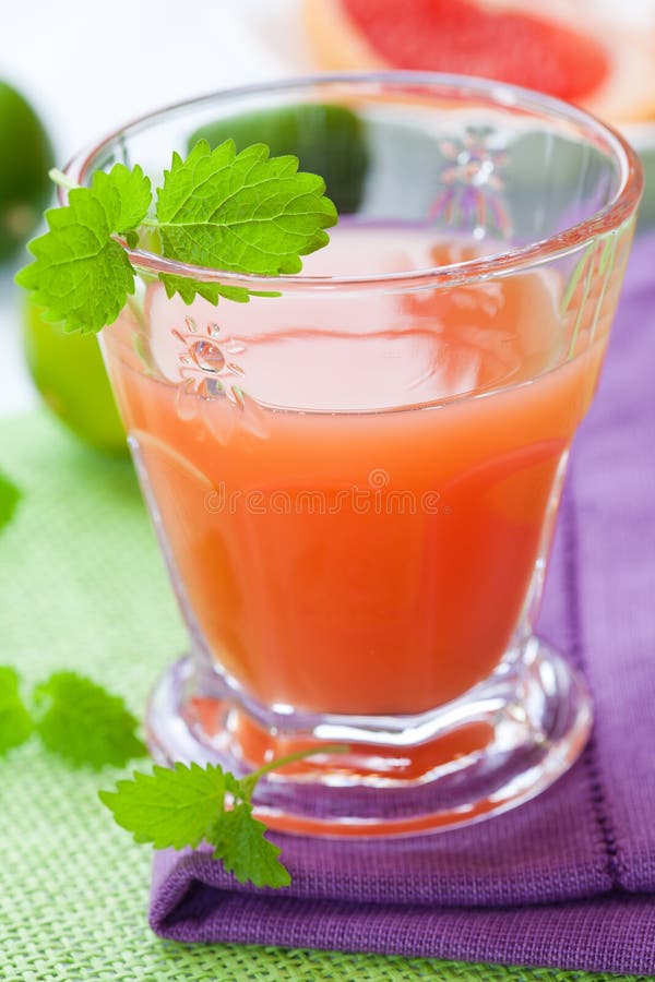 Glass of pink grapefruit juice with lemon mint