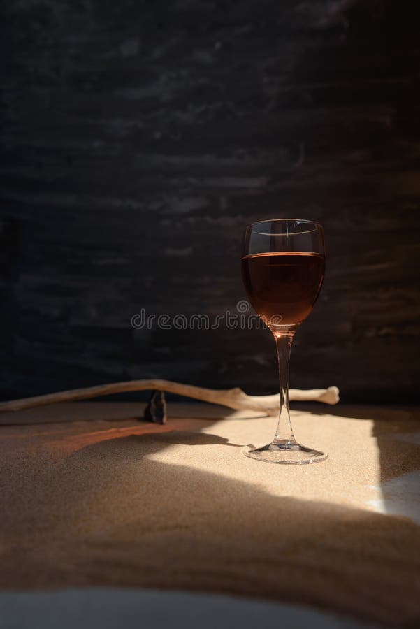 Glass of Red Wine in Arched Sunlight on the Sand. Stock Image Image