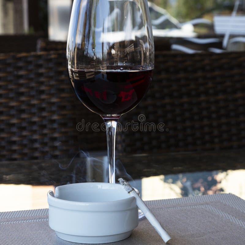 A Glass of Red Wine and a Cigarette on the Table Stock Photo Image of