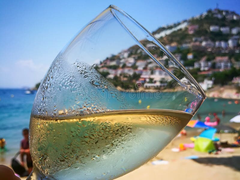 A Glass of refreshing cold white wine close up on beach restaurant.