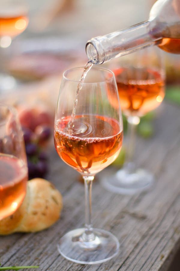 Glass of rose wine on picnic table. royalty free stock images