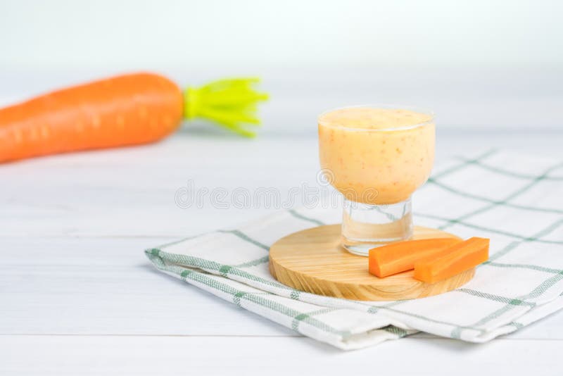Glass of salad dressing on white table with carrot ingredient royalty free stock images Glass of salad dressing on white table with carrot ingredient royalty free stock images