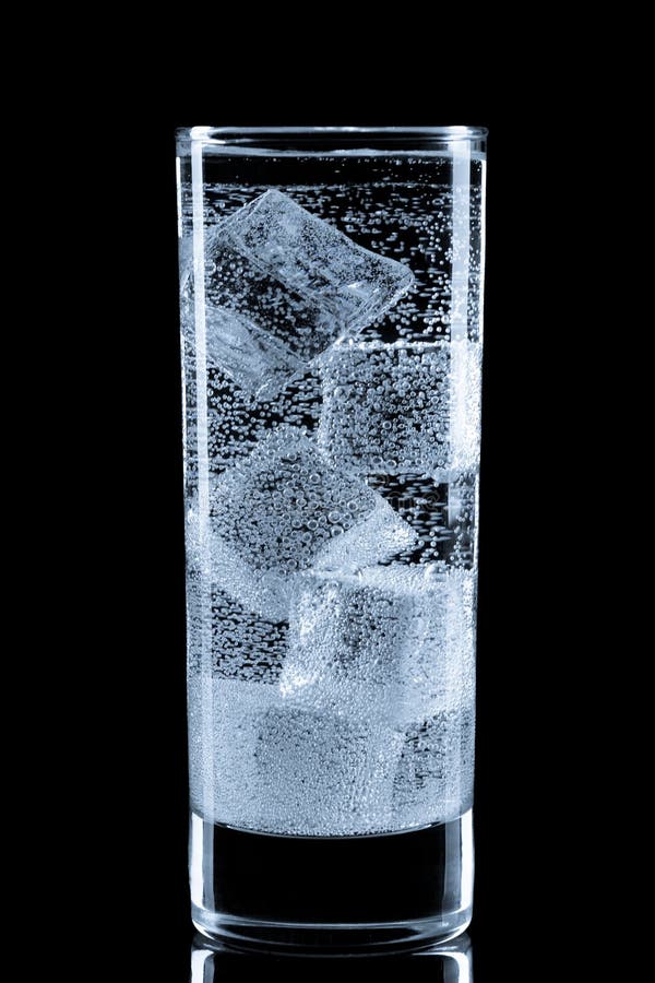 Glass with soda water and ice cubes. stock photos