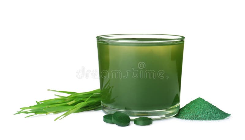 Glass of spirulina drink, powder, pills and wheat grass