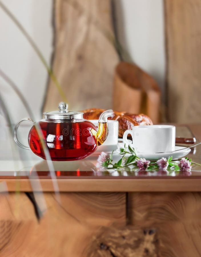 Glass Teapot Full of Black Tea with Two Cups of Tea on Table. Closeup