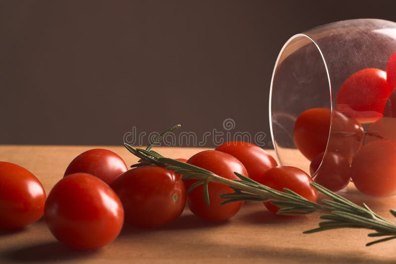 Cherry tomatoes spilling out from a wine glass on it's side. Cherry tomatoes spilling out from a wine glass on it's side.