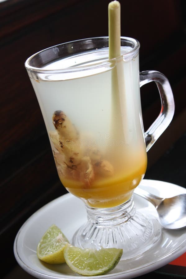 A Glass of Warm Ginger Drink and Lime. Decorated with Lemon Grass in the Glass Stock Photo