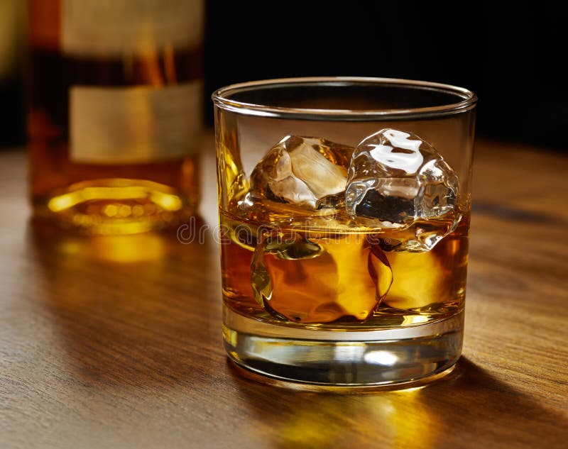 glass-whiskey-rocks-selective-focus-image-light-glowing-glass-whiskey-ice-bottle-wood-bar-