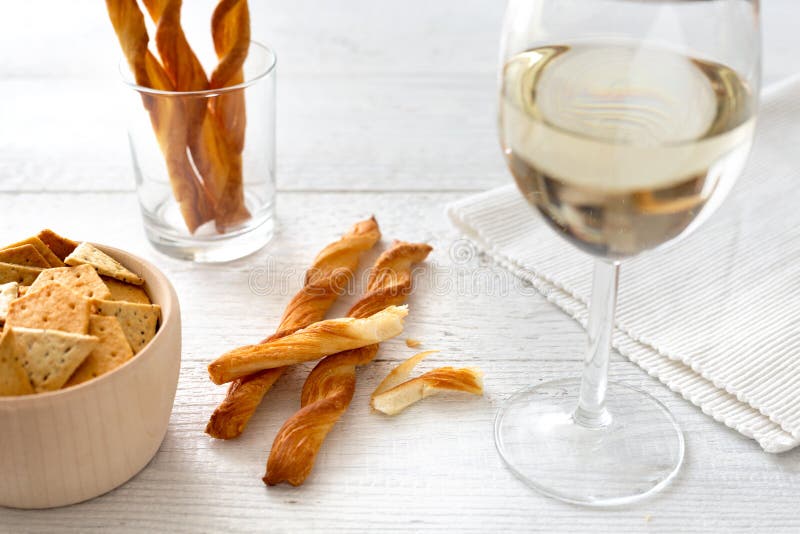 Glass of White Wine with Party Snacks on Rustic White Wooden Tab Stock