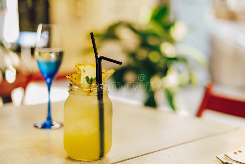 Glass of White Wine and Yellow Cocktail on the Table Stock Photo