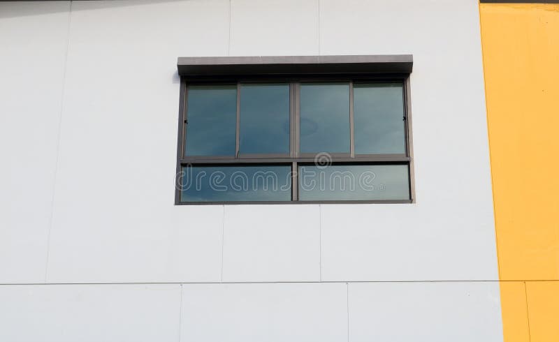 Glass windows with window tint film and reflect sky on surface.