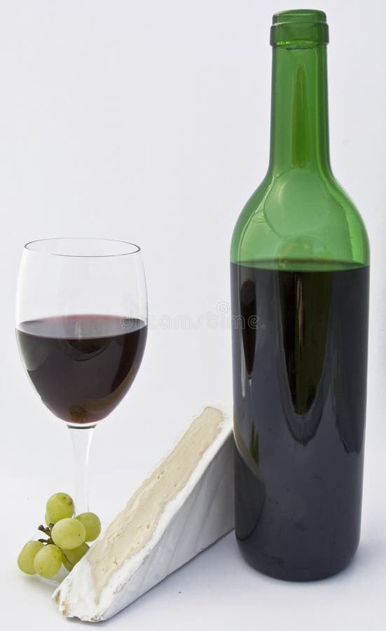 Glass of wine and bottle with grapes and cheese