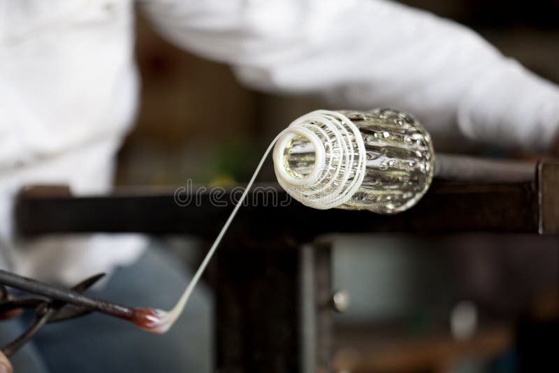 Glassblower shaping wrapping molten glass