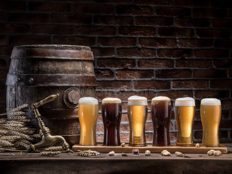 Glasses of beer and ale barrel on the wooden table. Craft brewery