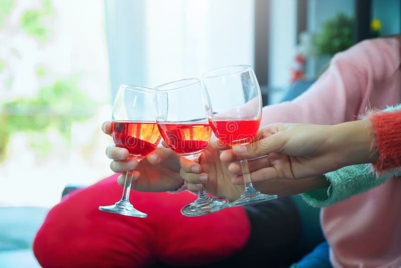 Glasses of champagne close up, celebration, eating and holidays concept - hands clinking wine glasses, Focus on hands toasting red