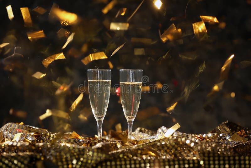 Glasses of Champagne with Falling Confetti on Dark Background Stock