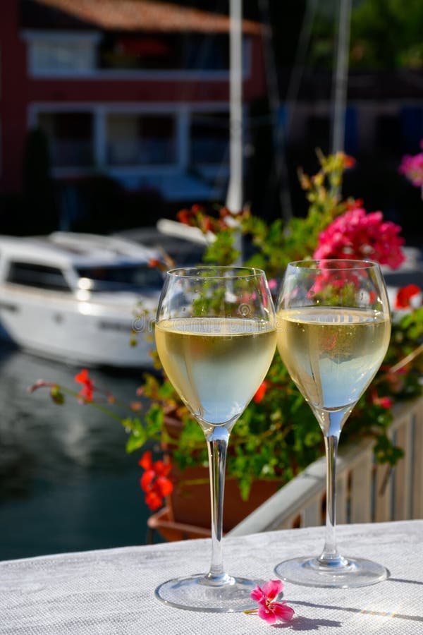Wine and cake of French Riviera, glasses of cold rose Cote de Provence wine and Tarte Tropezienne cake in yacht harbour of Port royalty free stock images