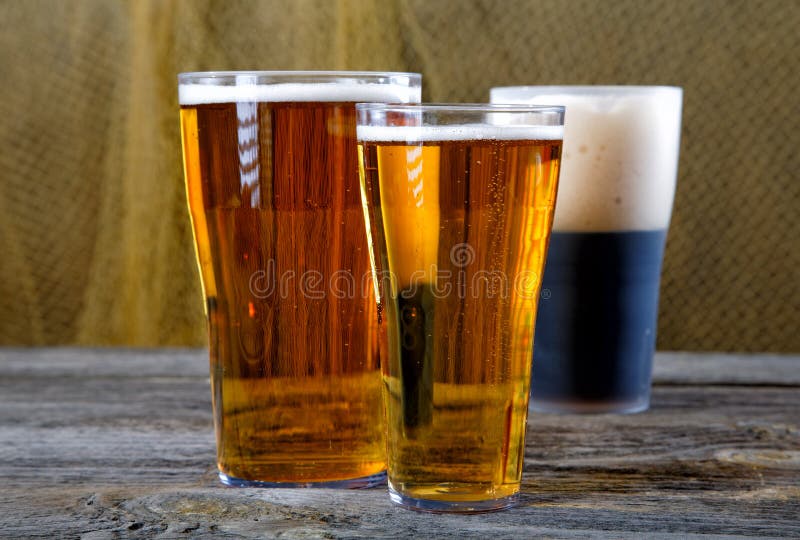 Glasses with dark and light beer on a table stock image Glasses with dark and light beer on a table stock image