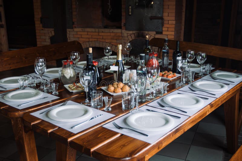 Glasses, Forks, Knives, Plates on a Table in Restaurant Served for