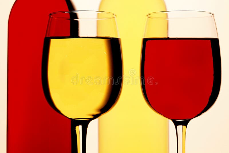 Glasses of Red and White Wine, with Red and White Wine Bottles Behind