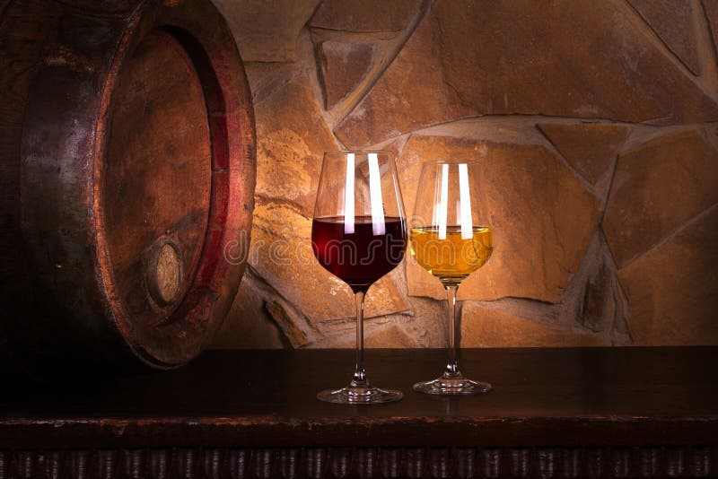 Glasses of Red and White Wine in Wine Cellar, Old Wine Barrel. Stock