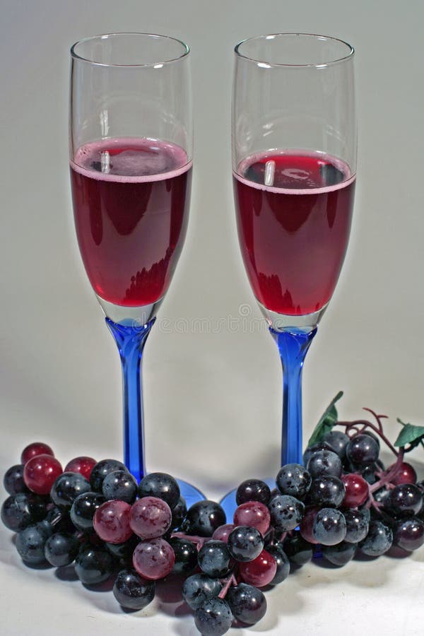 Glasses of red wine & red grapes stock image