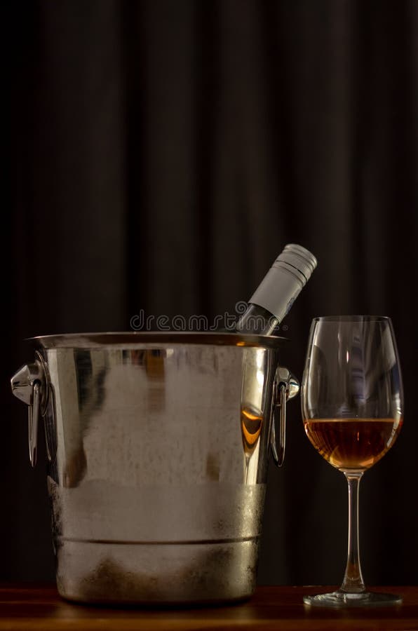 A glasses of Rose wine on wooden table with a bottle in wine chiller bucket royalty free stock images A glasses of Rose wine on wooden table with a bottle in wine chiller bucket royalty free stock images