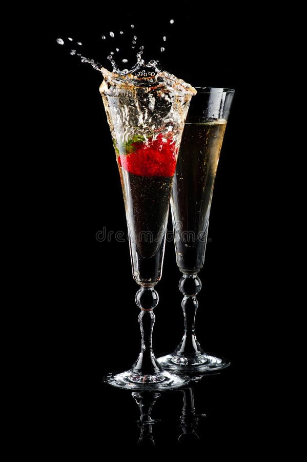 Two glasses of sparkling wine (champagne) with splash and strawberry on black. Two glasses of sparkling wine (champagne) with splash and strawberry on black