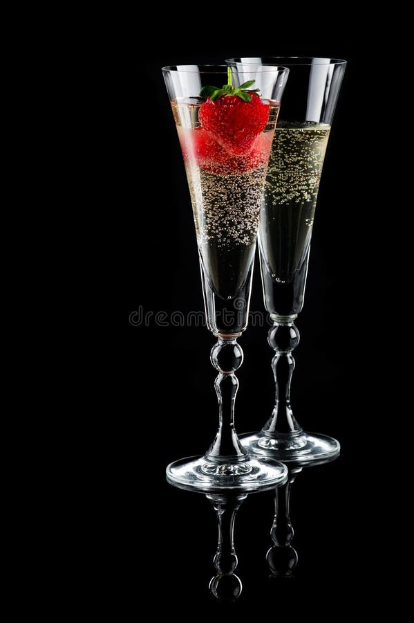 Two glasses of sparkling wine (champagne) and strawberry on black. Two glasses of sparkling wine (champagne) and strawberry on black