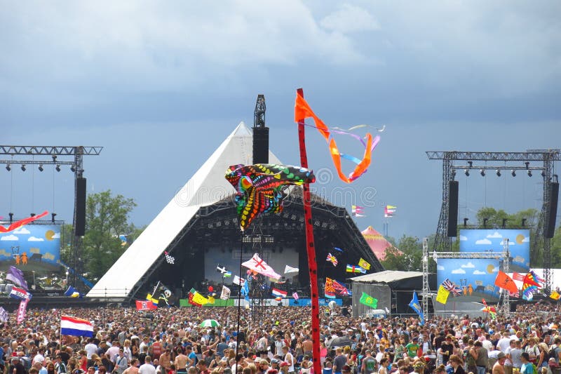 Glastonbury music festival Pyramid Stage crowds stormy sky