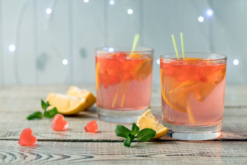 Glasögon med fräschande rosa citronade och hjärtformade iskuber på vitt träbord Drick på Alla hjärtans dag arkivfoto Glasögon med fräschande rosa citronade och hjärtformade iskuber på vitt träbord Drick på Alla hjärtans dag arkivfoto