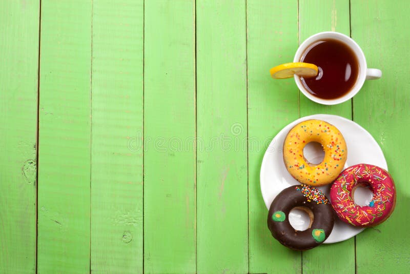 https://thumbs.dreamstime.com/b/glazed-donuts-cup-tea-green-wooden-background-copy-space-your-text-top-view-90271674.jpg