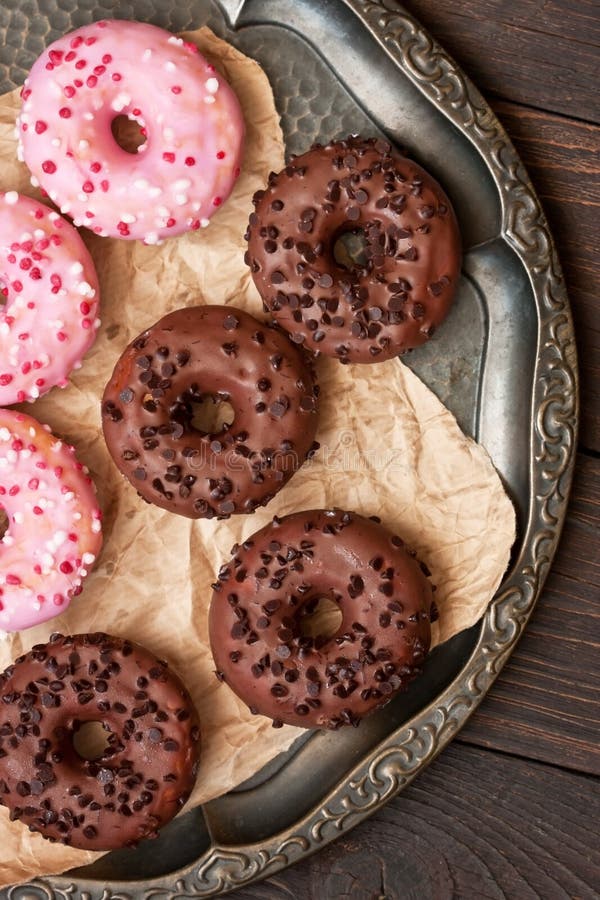 Glazed sweet mini donuts on wooden background