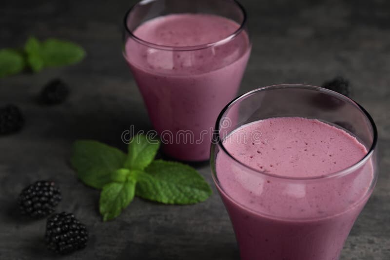 Glazen met braambessenyoghurt smoothies op grijze lijst royalty-vrije stock afbeeldingen Glazen met braambessenyoghurt smoothies op grijze lijst royalty-vrije stock afbeeldingen