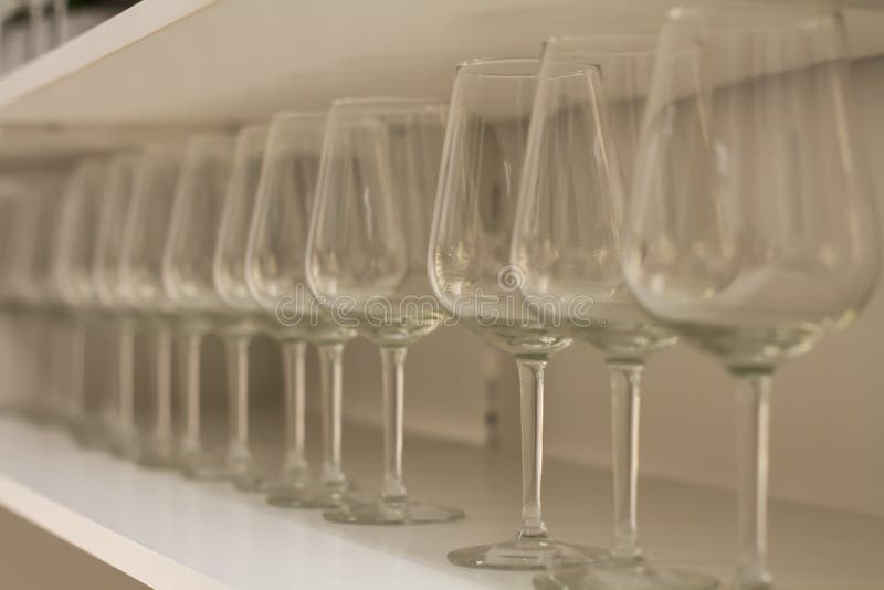 Glazen Van De Partij Verkopen De Duidelijke Wijn Op Hoog Been in Rij Op Rek De Stock Afbeelding - Image of beeld, 104055145